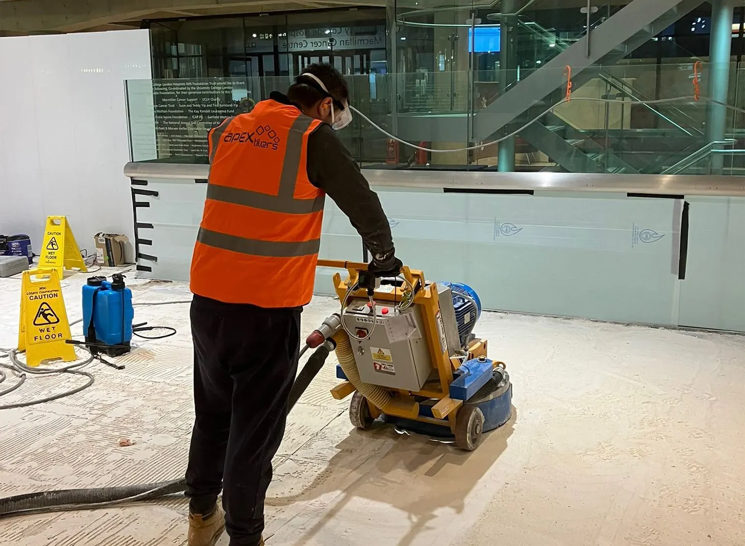Apex Tilers operative preparing a large commercial floor with a grinding machine