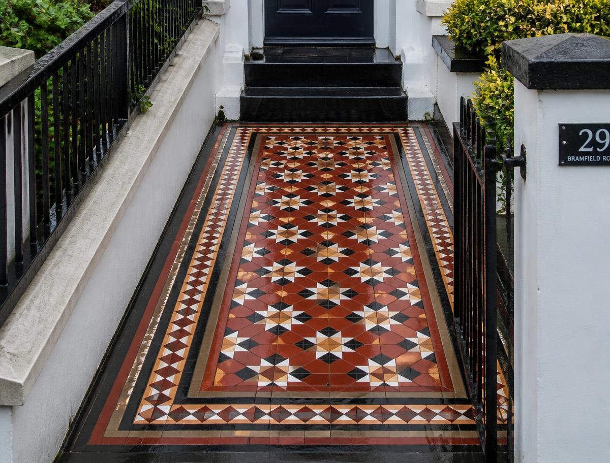 Restored Victorian geometric tiled pathway outside a London terraced house